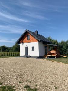 una pequeña casa blanca con techo negro en Ostoja Wilka en Grochowce
