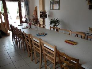 une salle à manger avec une table et des chaises blanches dans l'établissement GITE LES 1000 FLEURS, à Souteyros