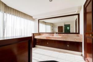 a bathroom with a large mirror and a sink at Penthouse Los Colomos in Guadalajara