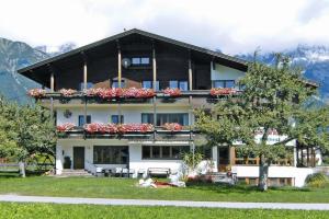 a large building with flowers on the balconies of it at Apartments home Bergbauernhof Wallnöfer, Mieming in Mieming