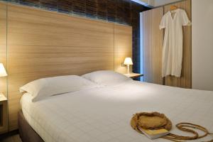 a bedroom with a bed with a robe hanging in a window at Hôtel L'Escale Coté Port in LʼÎle-Rousse