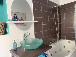 a bathroom with a bowl sink on a wooden counter at Appartement Villa Chausey, vue sur le port in Granville +30 photos