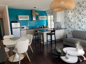 a kitchen and living room with a couch and a table at Appartement Villa Chausey, vue sur le port in Granville