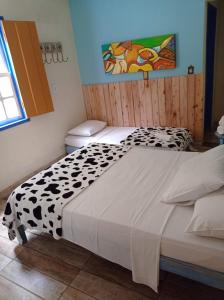 a bedroom with a bed with a black and white comforter at Pousada Caminho do Trem in Tiradentes