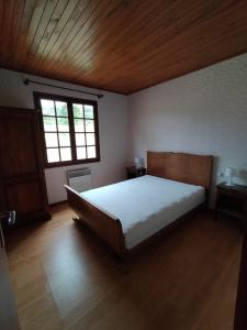 um quarto com uma cama grande e uma janela em Les Chaumes em Villiers-en-Morvan