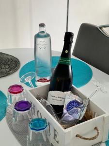 una caja con una botella de vino y copas en una mesa en Feliz Casa El Pinar Garrucha, en Garrucha