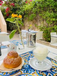 una mesa con dos donuts y un tazón en ella en La Moresca Maison De Charme, en Marina di Ragusa