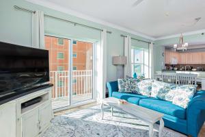 Crystal Shores West II في غولف شورز: غرفة معيشة مع أريكة زرقاء وتلفزيون