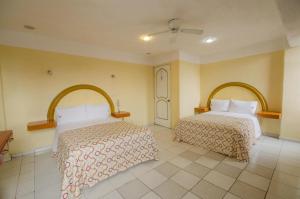 una habitación de hotel con 2 camas en una habitación en Hotel Central, en Puebla