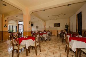a restaurant with red and white tables and chairs at Hotel Central in Puebla