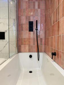 a bath tub with a shower in a bathroom at Sebastians in Oswestry