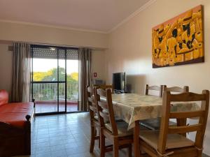 a dining room with a table and chairs and a television at Sol y Arena Plaza in San Clemente del Tuyú