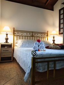 a bedroom with a bed with teddy bears on it at Pousada Casa do Oscar in Governador Celso Ramos