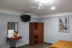 1 dormitorio con cama, espejo y ventilador de techo en Hotel Central en Puebla
