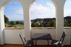 einen Tisch und zwei Stühle auf einem Balkon mit Aussicht in der Unterkunft Casa Oliveres Beach en L' Ampolla in Perelló