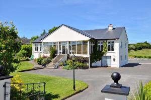 una casa blanca con muchas ventanas en Rowanville Lodge en Grange