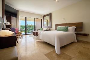 una camera con un grande letto bianco e un soggiorno di Hotel Xcaret Arte - All Parks All Fun Inclusive - Adults Only a Playa del Carmen