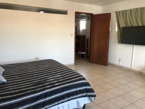 1 dormitorio con 1 cama y TV de pantalla plana en Departamento Belgrano III en Salta