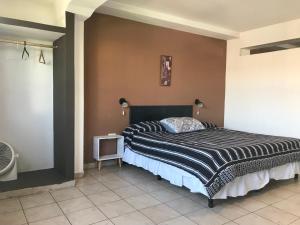 1 dormitorio con 1 cama con edredón blanco y negro en Departamento Belgrano III en Salta