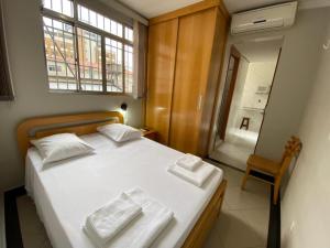 ein Schlafzimmer mit einem Bett mit zwei Handtüchern darauf in der Unterkunft Missouri Hotel in São Paulo