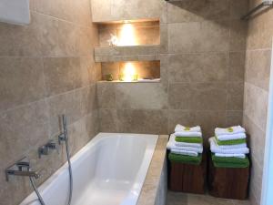 La salle de bains est pourvue d'une baignoire, d'un lavabo et de serviettes. dans l'établissement Ferienwohnung Design & Natur, à Ergetsweiler