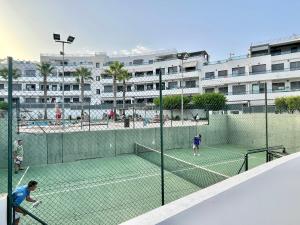 dos personas están jugando al tenis en una pista de tenis en Feliz Casa El Pinar Garrucha, en Garrucha