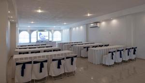 マンサニージョにあるHotel Fiesta Mexicanaの白いテーブルと椅子、スクリーンが備わる客室です。