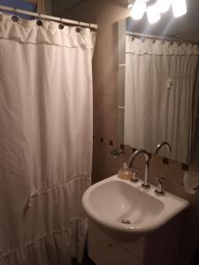 a bathroom with a sink and a shower curtain at Rufina Alojamiento in Playa Unión