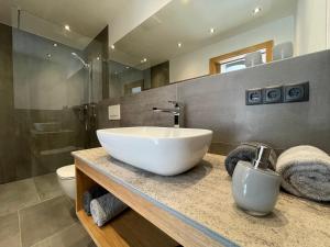 a bathroom with a large white bowl sink on a counter at HAUSZEIT APPARTEMENTS in Haus im Ennstal