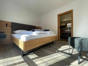 een slaapkamer met een groot bed en een spiegel bij HAUSZEIT APPARTEMENTS in Haus im Ennstal