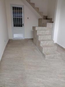 a room with a staircase and a door with a stair tread at Casa de praia no centro de Caraguatatuba in Caraguatatuba