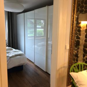 a bedroom with white cabinets and a mirror and a bed at Ferienwohnung Design & Natur in Ergetsweiler