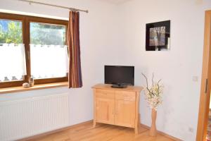 uma sala de estar com uma televisão num armário de madeira em Alpensonne em Krimml