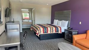 ヒューストンにあるExecutive Inn and Suites Houstonのベッドと椅子付きのホテルルーム