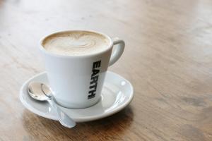 een kopje koffie op een bord met een lepel bij Herberg, Het Wapen van Tilburg in Tilburg
