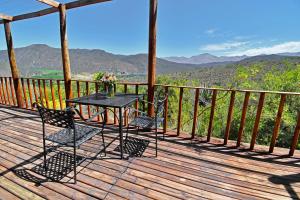 a picnic table with chairs and umbrellas at Le Petit Karoo Ranch in Oudtshoorn