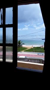 a window with a view of a beach and the ocean at Jacaraipe ES -Lar de Praia casa temporada in Jacaraípe