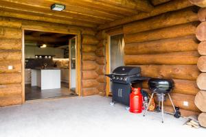 una barbacoa en una cabaña de madera con cocina en Luxusní srub až 24 lůžek - Sruby-lipno, en Frymburk