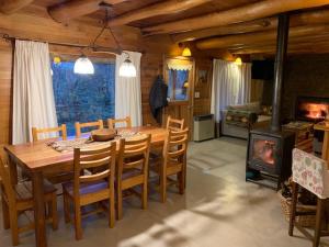 Un comedor con mesa y sillas y chimenea. en Casa Lago Hermoso, en San Martín de los Andes