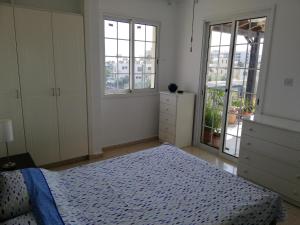 1 dormitorio con 1 cama y 2 ventanas en Ria Beach Sea View Apartment, en Pyla