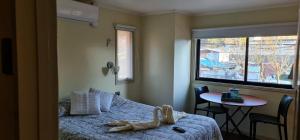 um quarto com uma cama, uma mesa e uma janela em La Ruta de Aysén em Coihaique