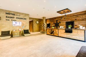a lobby of a hotel with two chairs and a counter at Hôtel Saint Charles Val Cenis in Lanslebourg-Mont-Cenis