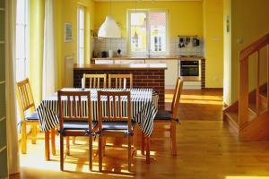 a dining room with a table and chairs and a kitchen at Holiday village Mamry directly on the lake in Trygort in Trygort