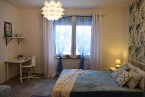 1 dormitorio con cama, escritorio y ventana en Holiday flat, Kamien, en Kamień