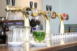 a kitchen counter with glasses and a sink with a green drink at Herberg, Het Wapen van Tilburg in Tilburg