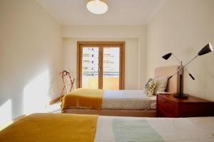 Tempat tidur dalam kamar di Cozy Red Telheiras Apartment