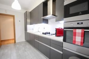 Cuisine ou kitchenette dans l'établissement Cozy Red Telheiras Apartment