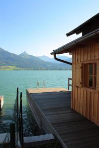 un muelle de madera con dos grifos en el agua en Pension Linortner en St. Wolfgang