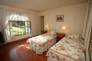 a hotel room with two beds and a window at Posada Don Salvador in San Antonio de Areco