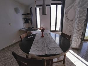 a dining room table with a vase of flowers on it at Suítes Bela Vista in Japaratinga